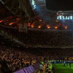 футбольный стадион вечером с болельщиками