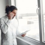 человек с купоном ставок смотрит на телефон