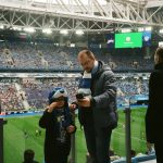 болельщик спокойно следит за матчем на телефоне